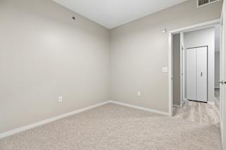 A room with a white door and carpeted floor.