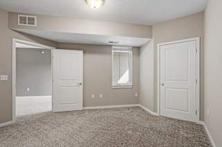 A room with a carpeted floor and a window.