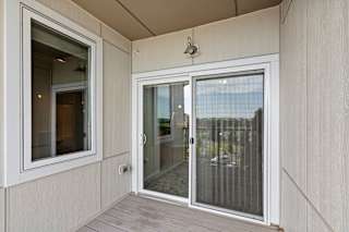 A balcony with a glass door and a window.