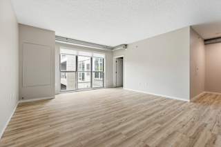 A room with wooden flooring and a sliding glass door.