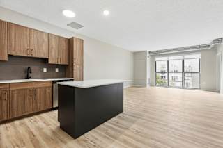 A kitchen with wooden cabinets and a black island.
