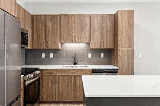 A modern kitchen with wooden cabinets and stainless steel appliances.