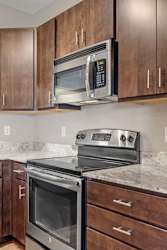 A modern kitchen with a stainless steel oven and microwave.