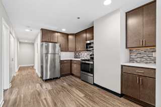 Kitchen with wooden floors and a stainless steel refrigerator at The Cosmopolitan, Minnesota, 55101