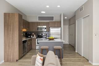 A modern kitchen with a bar stool and a couch.