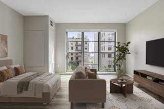 A bedroom with a large bed, a couch, a coffee table, and a flat-screen TV.