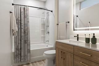 A bathroom with a toilet, sink, and shower.