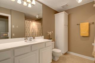 A bathroom with a white toilet and a white cabinet.