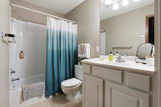 A bathroom with a toilet, sink, and shower.