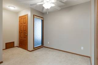 A dining room with a ceiling fan and a door.