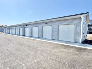 A long building with grey doors and a grey roof.