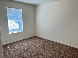 an empty room with carpet and a window at Shenandoah Properties in Lafayette, IN 47905