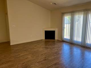 A room with a fireplace and wooden floors.