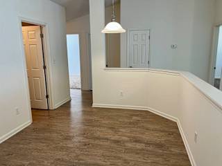 an empty living room with wood flooring and white walls at Shenandoah Properties in Lafayette, IN 47905