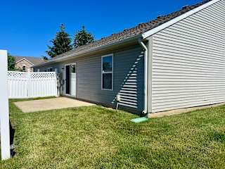 the side of a house with a yard and a white fence at Shenandoah Properties in Lafayette, IN 47905