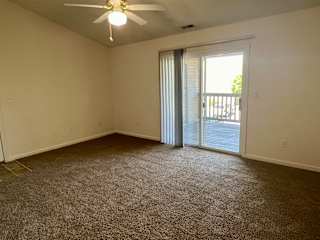 an empty living room with a sliding glass door to a balcony at Shenandoah Properties in Lafayette, IN 47905