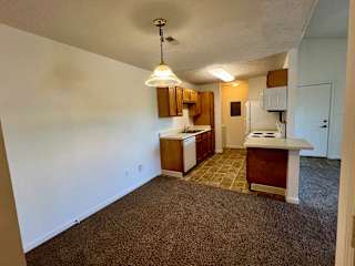an empty kitchen with white walls and a carpeted floor at Shenandoah Properties in Lafayette, IN 47905