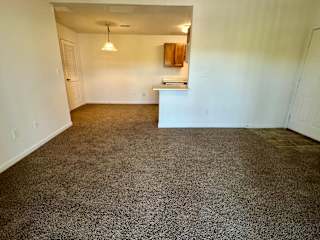 an empty living room with a carpeted floor and white walls at Shenandoah Properties in Lafayette, IN 47905