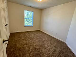 an empty room with carpet and a window at Shenandoah Properties in Lafayette, IN 47905