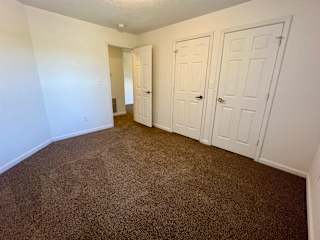 a bedroom with two closets and a carpeted floor at Shenandoah Properties in Lafayette, IN 47905