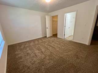 an empty living room with carpeting and a closet at Shenandoah Properties in Lafayette, IN 47905