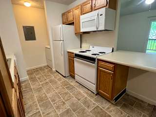 a kitchen with white appliances and wooden cabinets at Shenandoah Properties in Lafayette, IN 47905