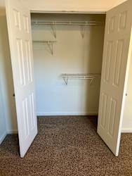 an empty closet with two doors and a carpeted floor at Shenandoah Properties in Lafayette, IN 47905