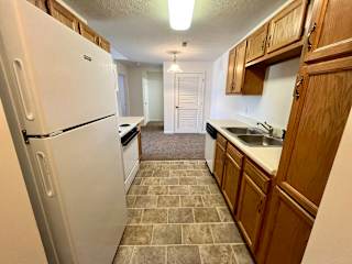 a kitchen with white appliances and wooden cabinets at Shenandoah Properties in Lafayette, IN 47905
