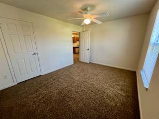 an empty living room with carpet and a ceiling fan at Shenandoah Properties in Lafayette, IN 47905