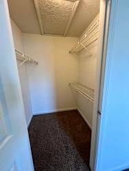 a walk in closet with two empty shelves and a door at Shenandoah Properties in Lafayette, IN 47905