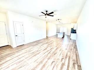 A room with a ceiling fan and wooden flooring.at Concord Crossing, Lafayette, IN