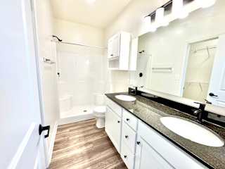 A white bathroom with a sink, mirror, and toilet.at Concord Crossing, Lafayette