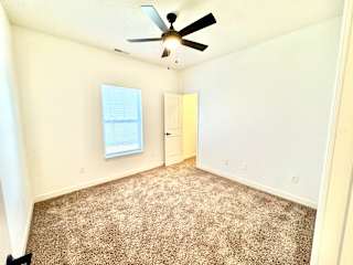 A room with a ceiling fan and carpeted floor.at Concord Crossing, Indiana