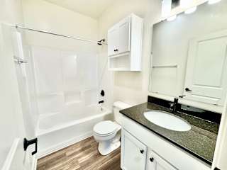 A white bathroom with a sink, toilet, and a shower.at Concord Crossing, Lafayette Indiana
