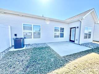 A house with a grey siding and a black door is shown.at Concord Crossing, Lafayette, 47909