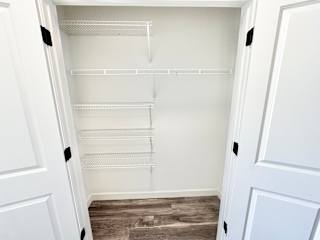 A white empty pantry with a white door and a white fridge.at Concord Crossing, Indiana