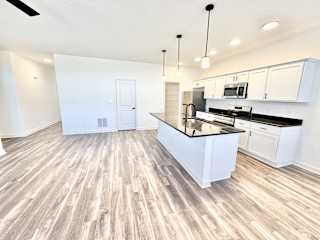 A kitchen with a white island and black countertops.at Concord Crossing, Lafayette