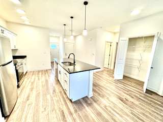 A kitchen with black countertops and white cabinets.at Concord Crossing, Lafayette, IN 47909
