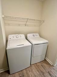 Two white front loading washing machines in a laundry room.
