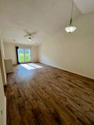 A room with wooden floors and a ceiling fan.