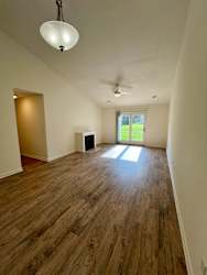 A room with wooden floors and a ceiling fan.