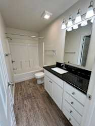 A bathroom with a sink, mirror, and toilet.