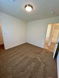 A room with a carpeted floor and a ceiling light.
