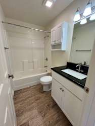 A white bathroom with a toilet, sink, and bathtub.