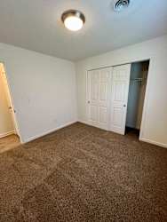 A room with a carpeted floor and a white door.