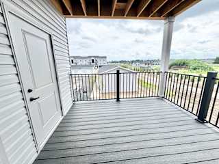 A white door is on the left of a balcony.