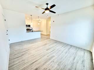 A room with a ceiling fan and wooden flooring.