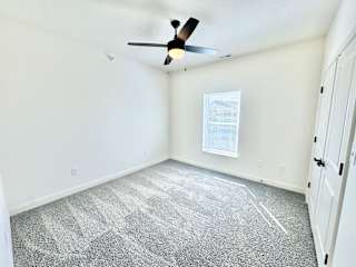 A room with a ceiling fan and a window.