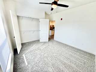 A room with a ceiling fan and a carpeted floor.