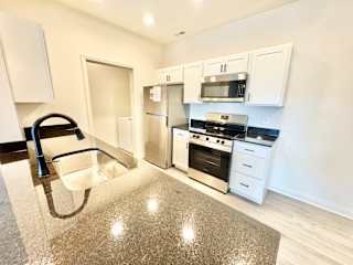 A kitchen with white cabinets and a granite countertop.